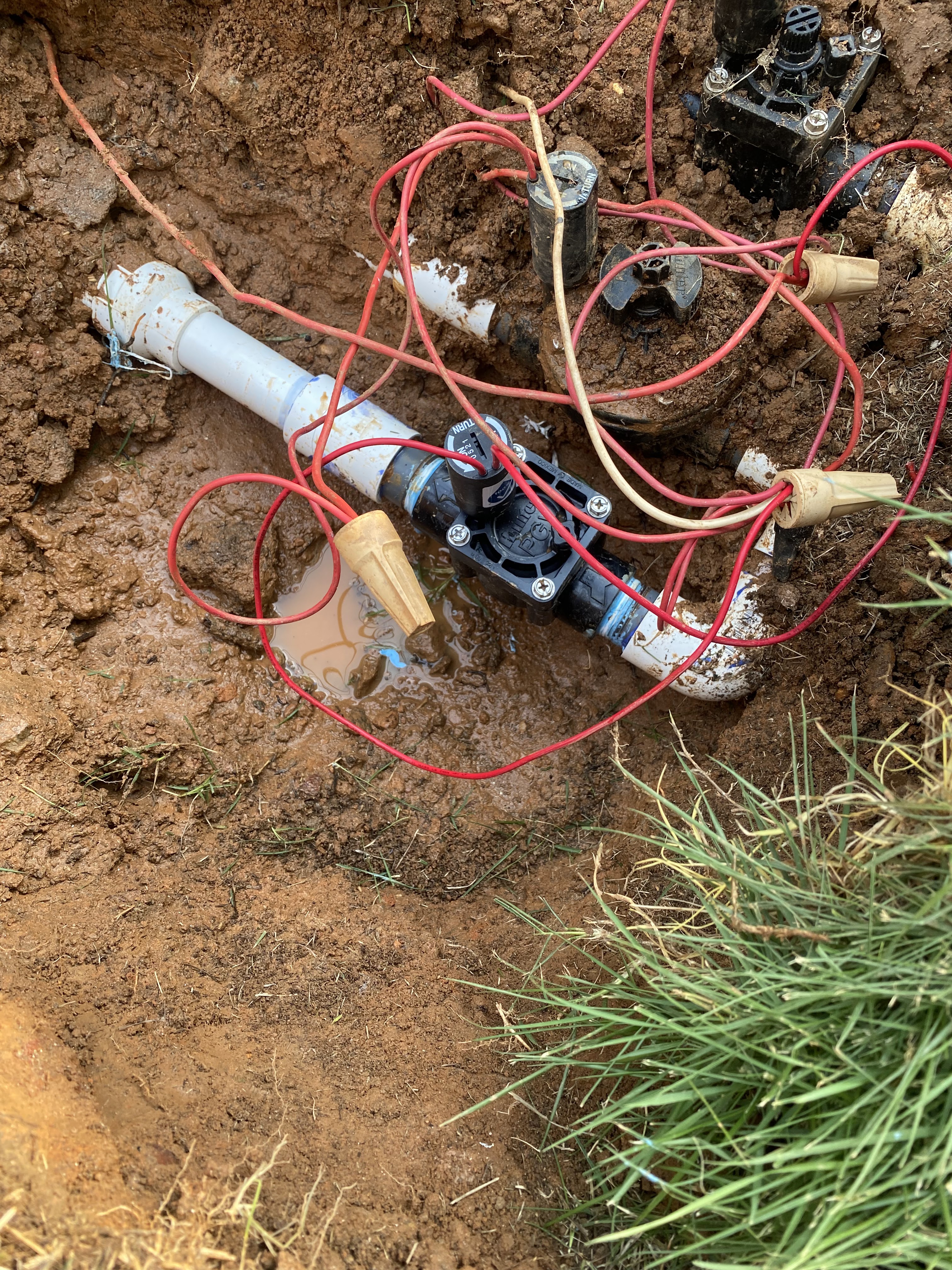 pipe with wires and a hose laying in the dirt